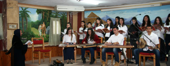 Преподаватель музыки г-жа Аггелу со своими учениками во время концерта