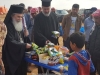 Prea Fericitul Patriarh și Pr. Issa distribuind jucării